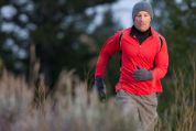 Mann joggt im Winter mit Handschuhen und Mütze über Feld und Flur Mann joggt im Winter mit Handschuhen und Mütze über Feld und Flur